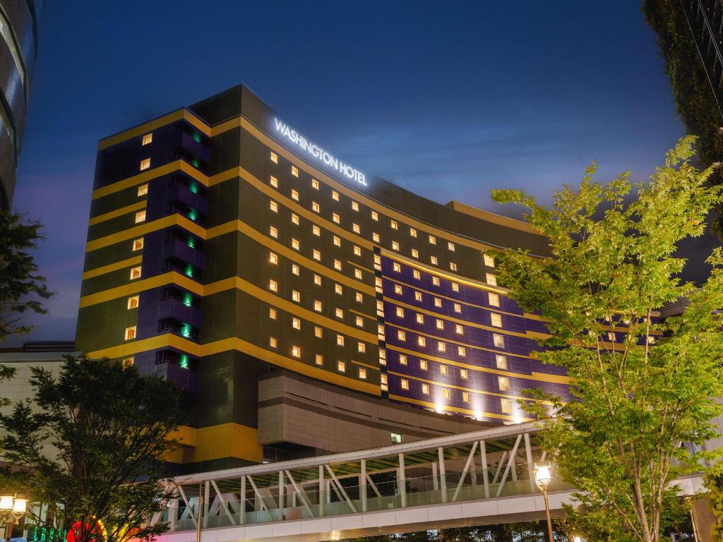 야간 조명이 켜진 커낼 시티 후쿠오카 워싱턴 호텔 외관과 WASHINGTON HOTEL 간판