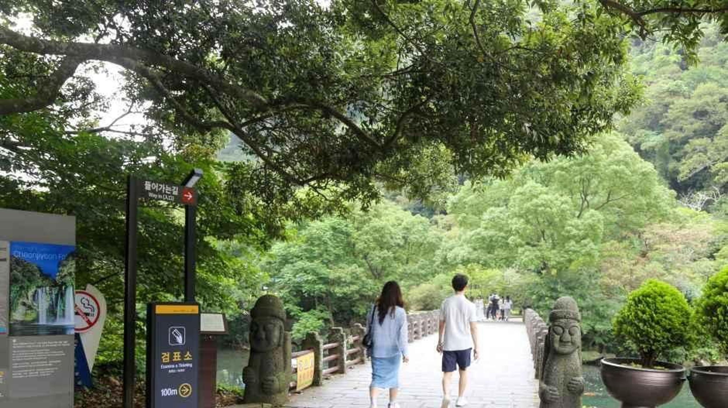 돌하르방이 양옆에 서 있는 천지연폭포 진입로 다리