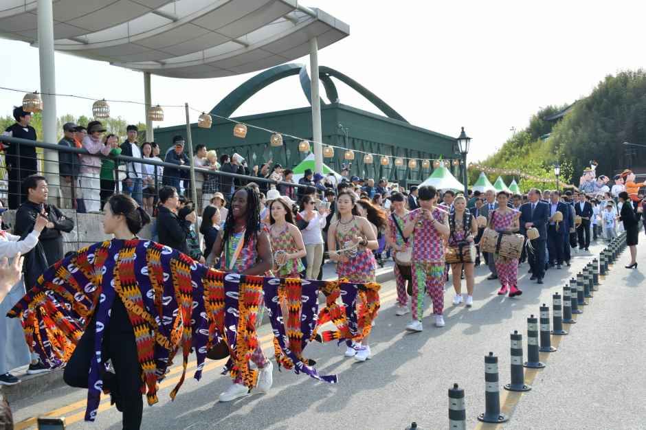 화려한 전통 문양 의상을 입은 공연단이 죽녹원 입구 다리 위에서 개막 퍼레이드 행진을 하는 모습