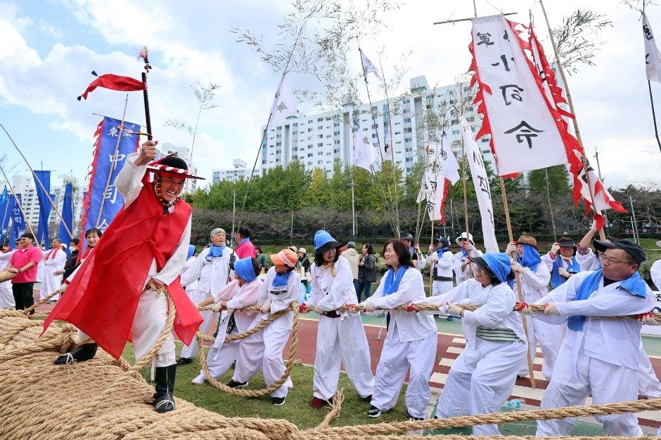 전통 복장의 사람들이 큰 줄을 함께 잡고 줄다리기를 하는 동래읍성역사축제 현장