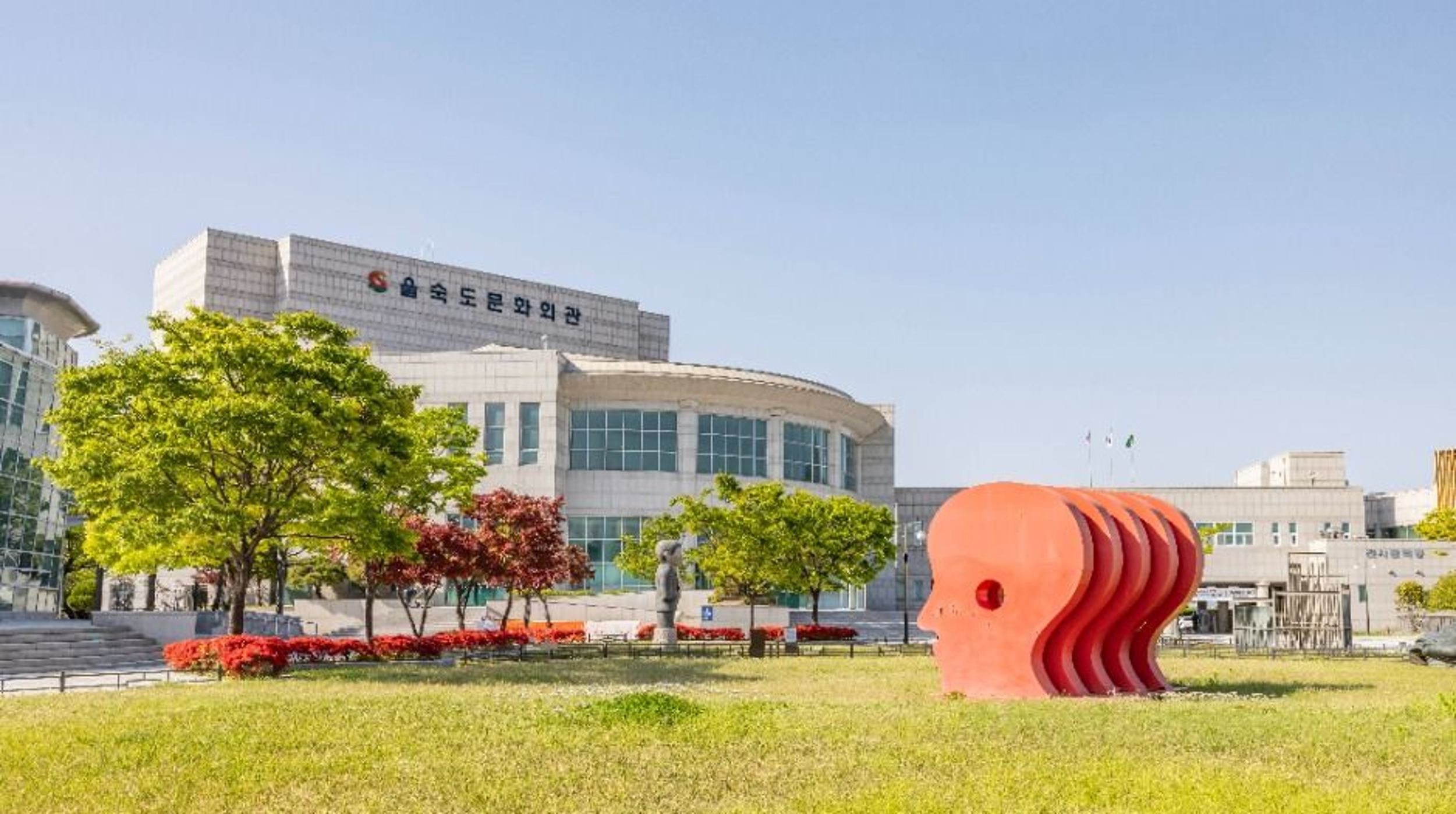 을숙도문화회관 앞 잔디밭에 놓인 붉은 얼굴 조형물