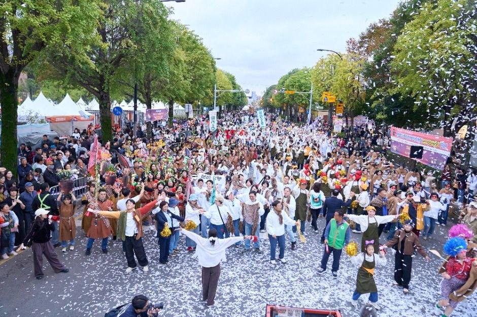 거리에서 주민들이 모여 퍼레이드를 하며 흰 꽃가루가 날리는 강동선사문화축제