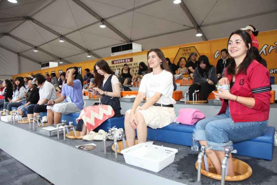 여러 명이 나란히 앉아 홍삼 족욕을 즐기는 모습
