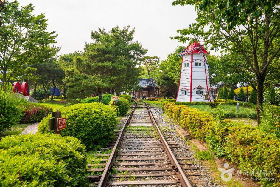 섬진강기차마을 기찻길과 풍차 조형물, 초록빛 정원이 어우러진 풍경