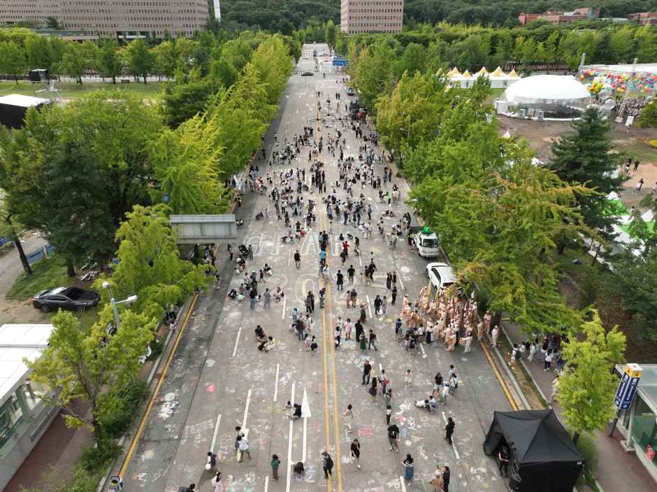 가로수길 도로를 가득 채운 시민 퍼레이드 참가자와 관람객들을 위에서 내려다본 모습