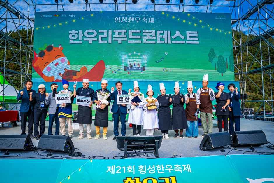 요리사 복장을 한 참가자들과 관계자들이 무대 위에서 한우리 푸드콘테스트 시상을 받고 기념 촬영하는 모습