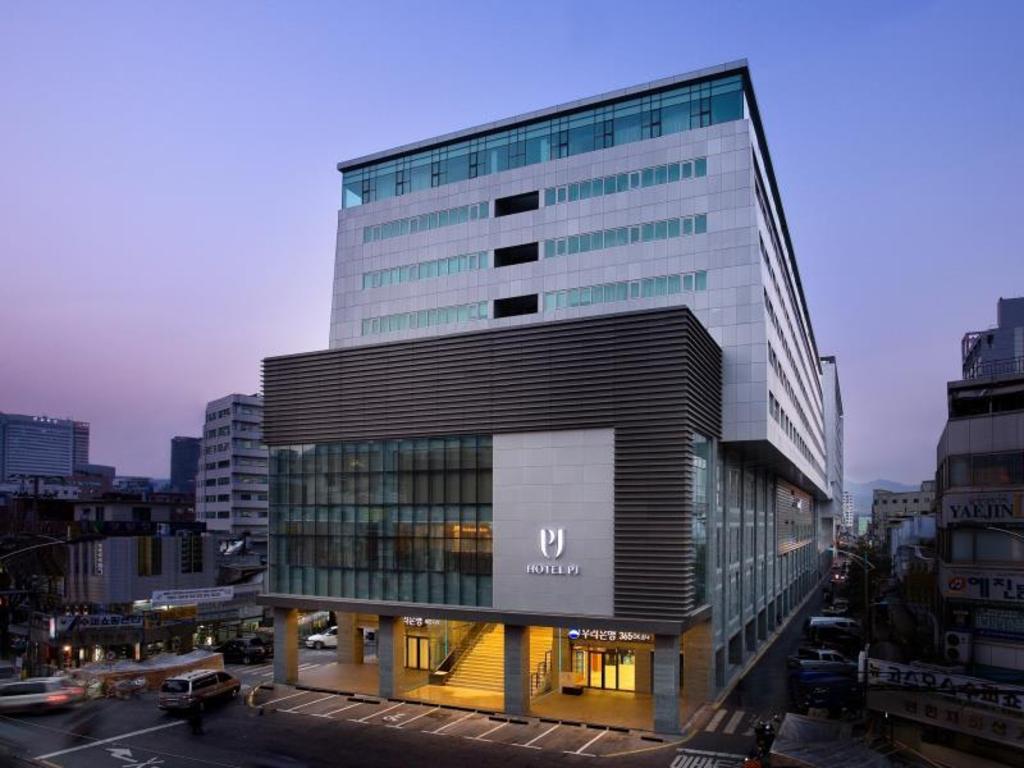 해 질 무렵 도심 골목 사이로 보이는 호텔 피제이 명동 건물 외관