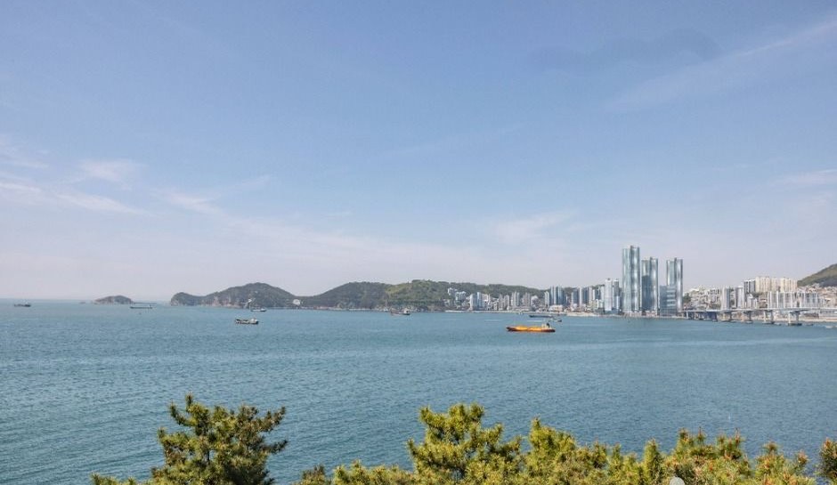 흰여울문화마을 난간 너머로 영도 바다와 부산 도심이 보이는 풍경