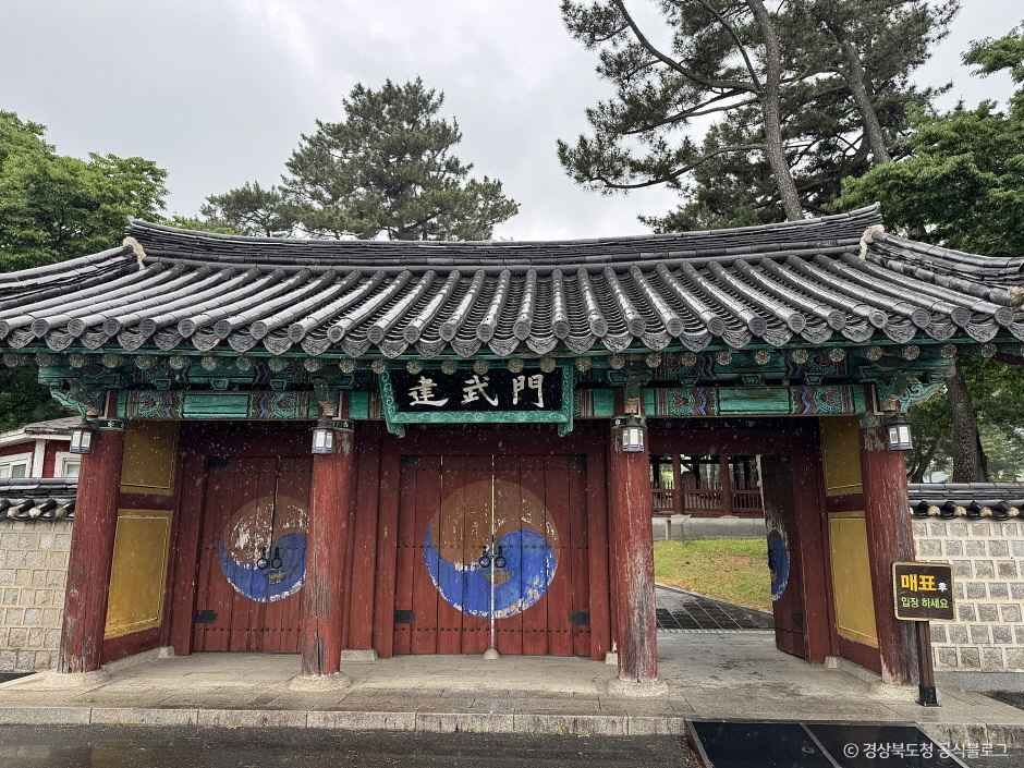 기와지붕과 단청 문이 보이는 무열왕릉 입구 문루