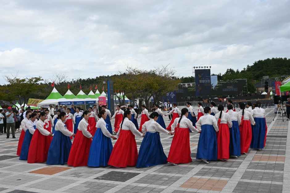 빨강과 파랑 한복을 맞춰 입은 참가자들이 손을 잡고 강강술래를 도는 모습
