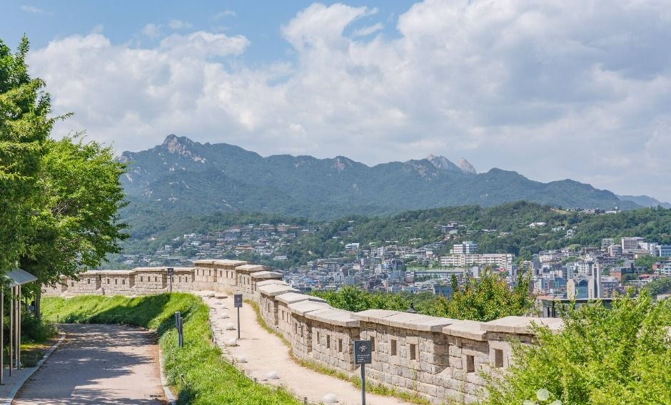 한양도성 성곽길 너머로 북한산과 서울 도심이 펼쳐지는 낙산공원 전경