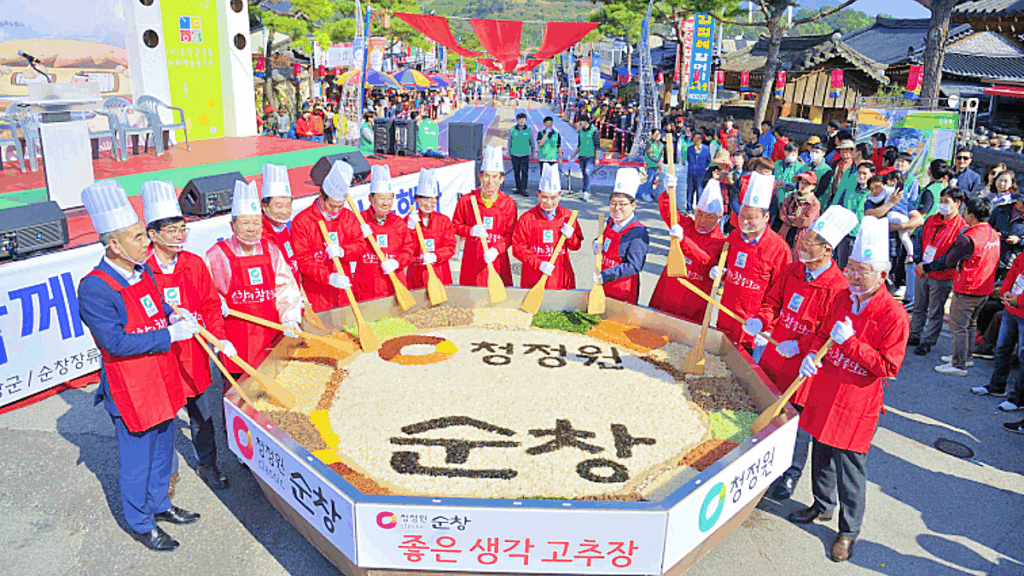 초대형 고추장 비빔 행사에서 긴 주걱으로 함께 비비는 참가자들