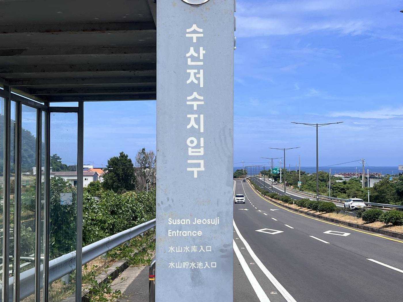 수산저수지입구 버스정류장 표지판과 도로