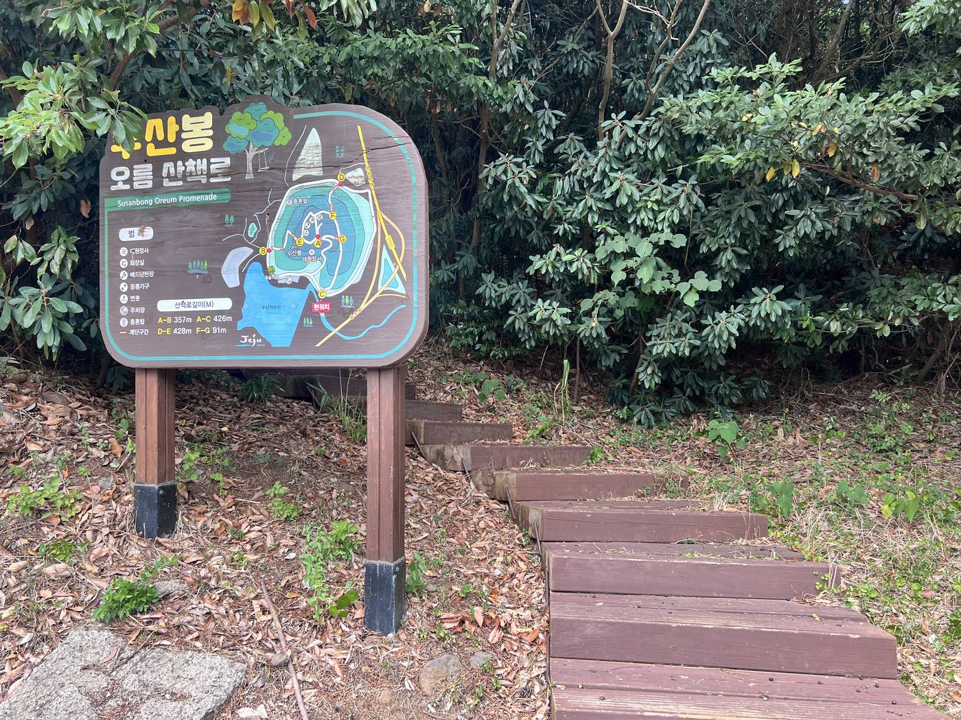 수산봉 오름 산책로 안내판과 나무 계단 입구