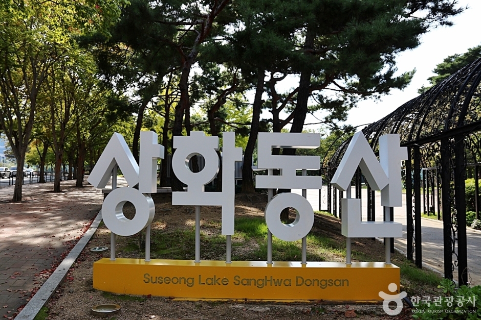 상화동산이라고 쓰인 대형 조형 글자와 뒤로 이어지는 나무 산책로