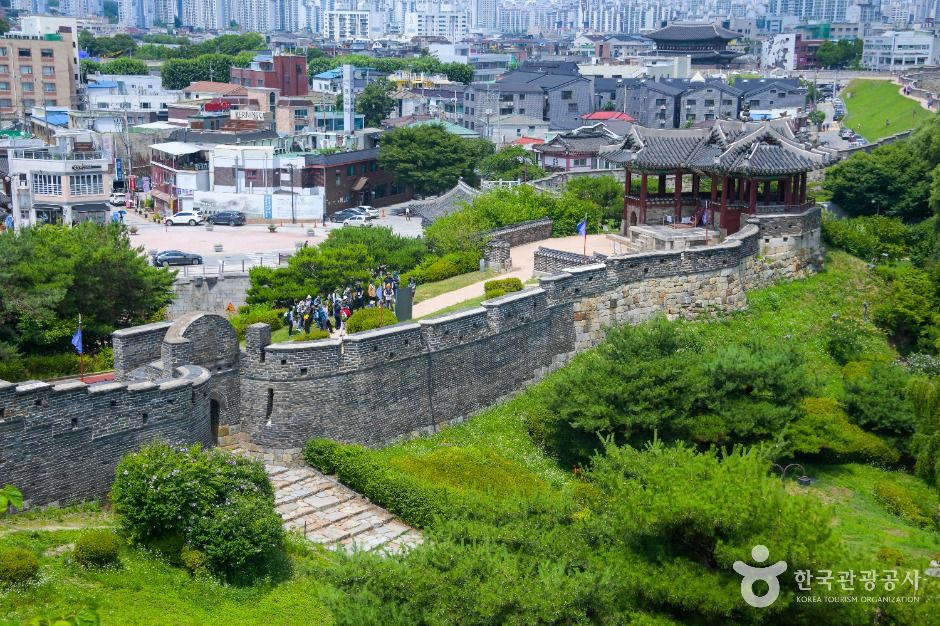 수원화성 성벽과 누각이 도심의 건물 사이로 이어지는 전경