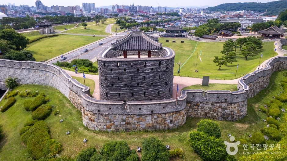 수원화성 성벽 위로 이어지는 산책로와 주변 도심 풍경