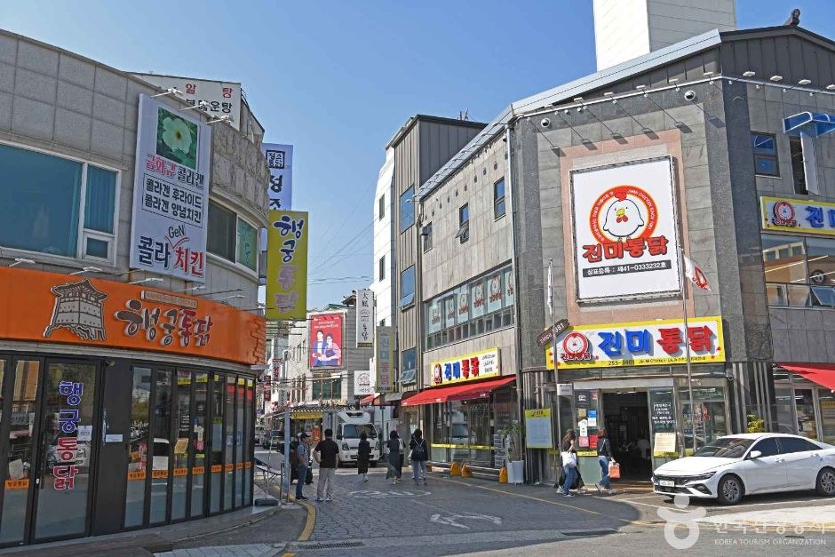 통닭 가게 간판이 늘어선 수원 통닭거리 길과 파란 하늘