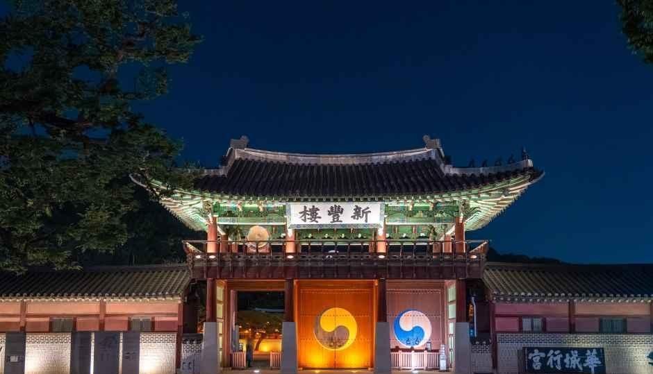 밤에 조명이 켜진 화성행궁 신풍루 정문과 앞에 놓인 조형물