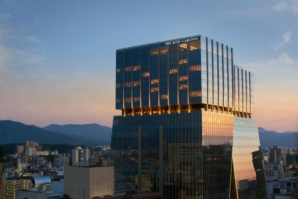 노을 지는 하늘 아래 THE RITZ-CARLTON 간판이 보이는 더 리츠칼튼 후쿠오카 건물 외관