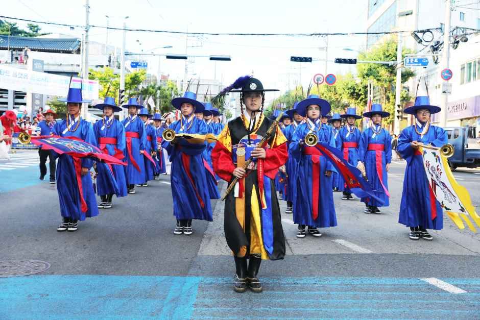 갑옷과 깃발을 갖춘 전통 복장 행렬이 도심 도로를 따라 삼도수군통제사 행차를 재현하는 모습