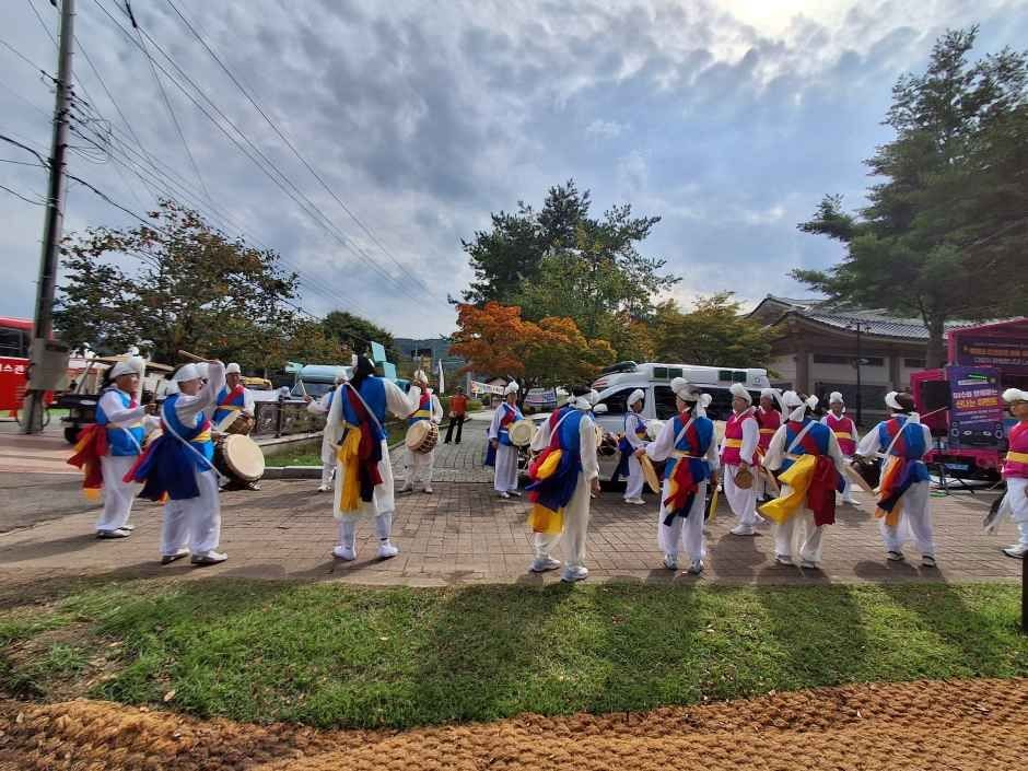 전통 의상을 입은 행렬이 북을 치며 축제장 길을 지나는 모습