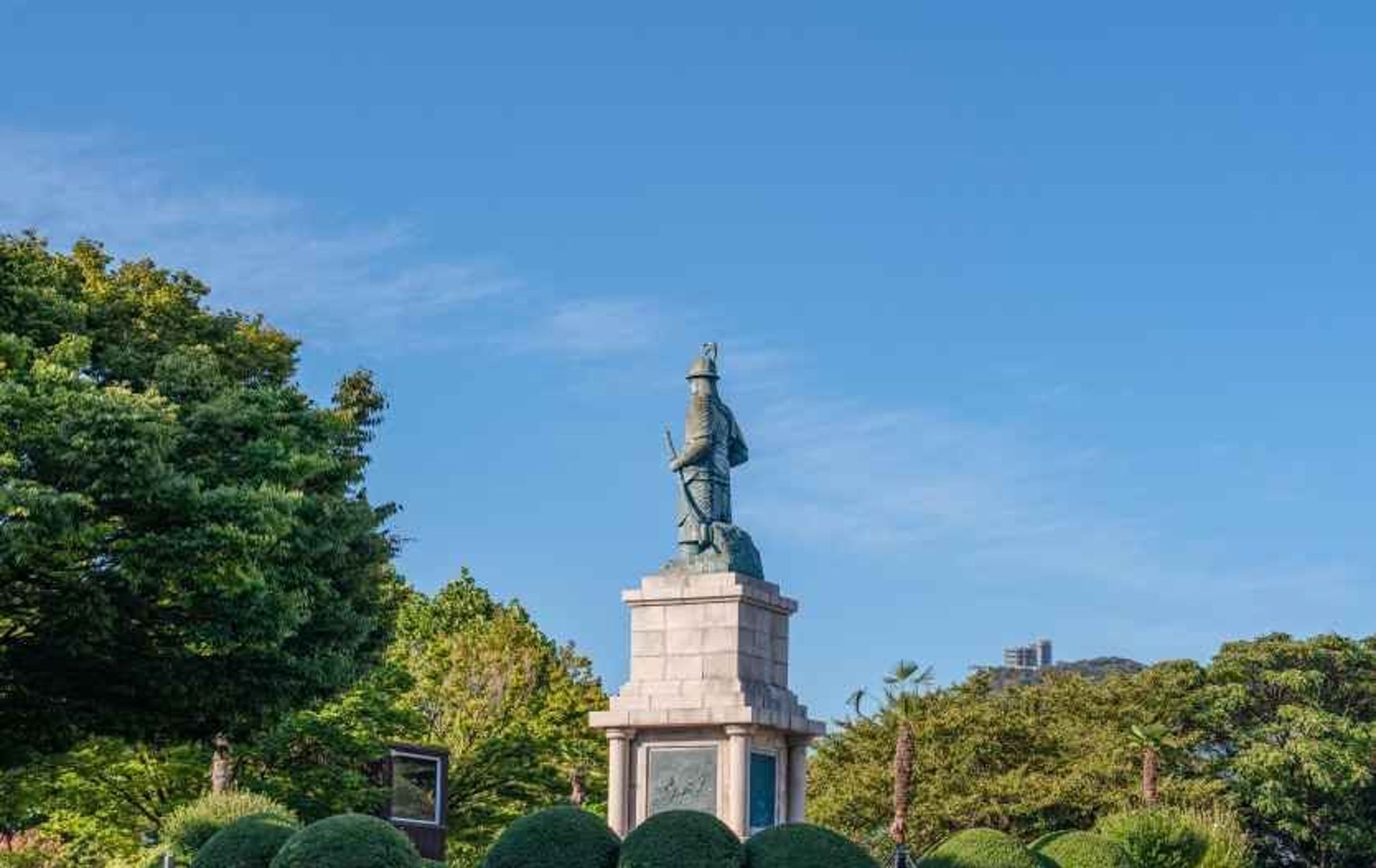 나무 사이로 이순신 장군 동상이 보이는 용두산공원 진입로